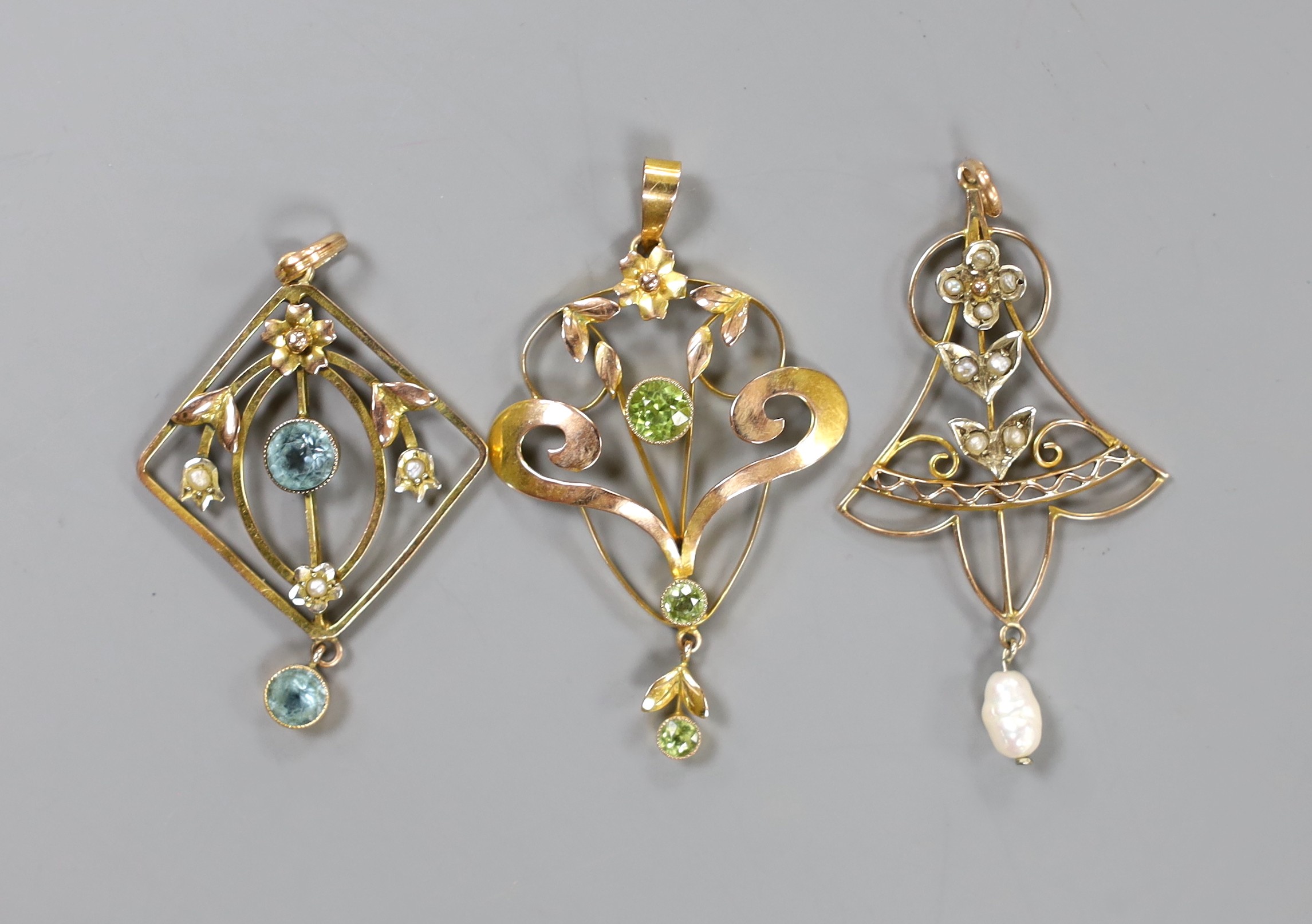 Three assorted Edwardian yellow metal and gem set pendants, including a 9ct and three stone peridot, 43mm, gross weight 5.9 grams.